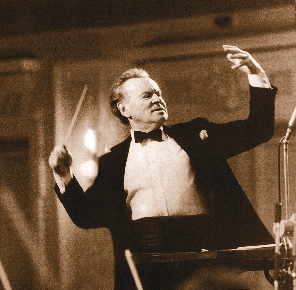 Evgeny Svetlanov, in the midst of conducting, is leading with all his heart, passionately guiding the orchestra with his baton.